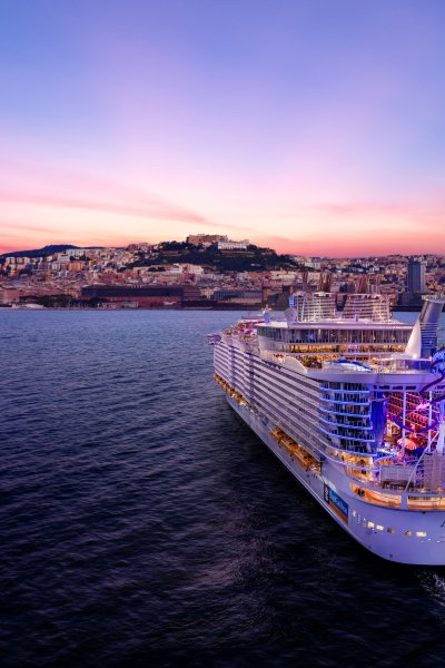 Panoramic view from sea of Naples coastline, Italy. Big cruise ships are in port, cityscape in sunny weather with blue sky and white clouds.